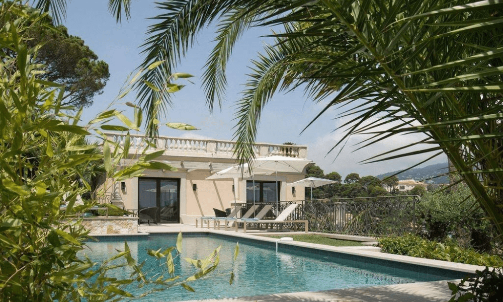 Garden and pool illuminated at dusk near sea views